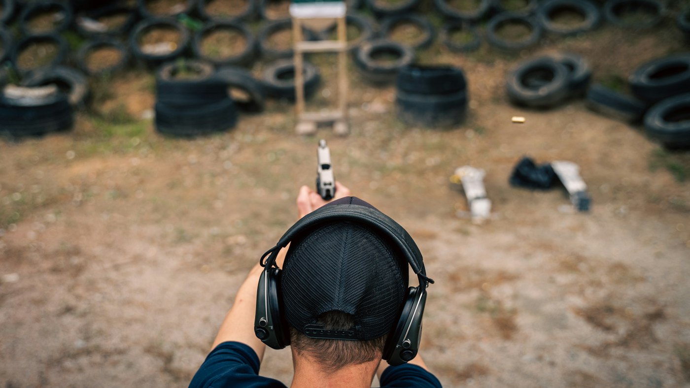 Tirador con cascos de protección en un campo de tiro
