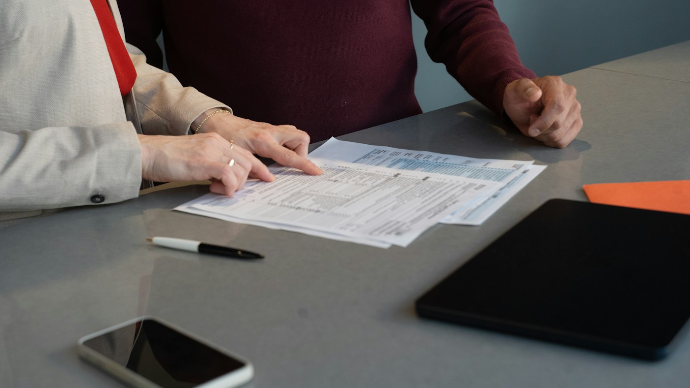 Mesa con formularios, un bolígrafo y una tableta
