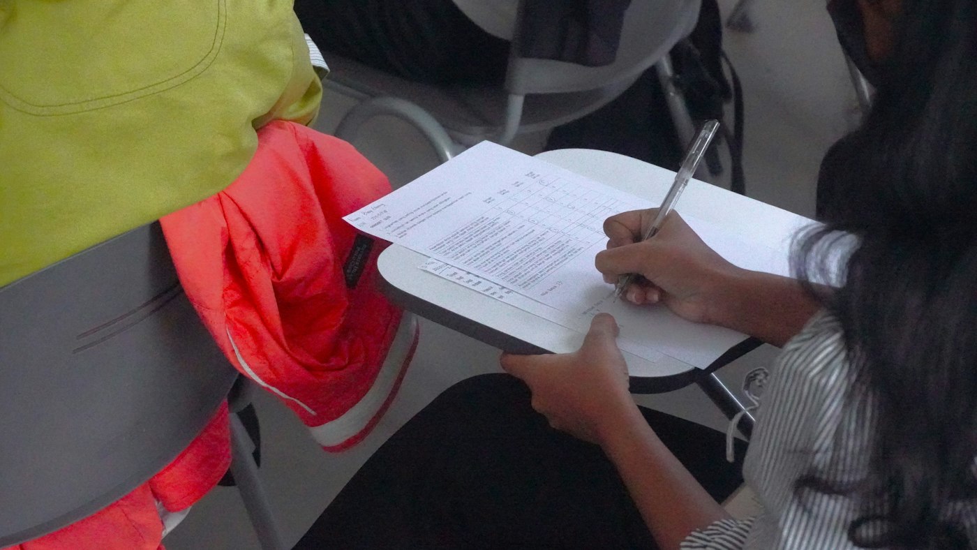 Estudiante escribiendo en un cuaderno durante un examen
