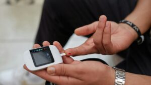 Persona midiéndose la glucosa en el dedo con un glucómetro